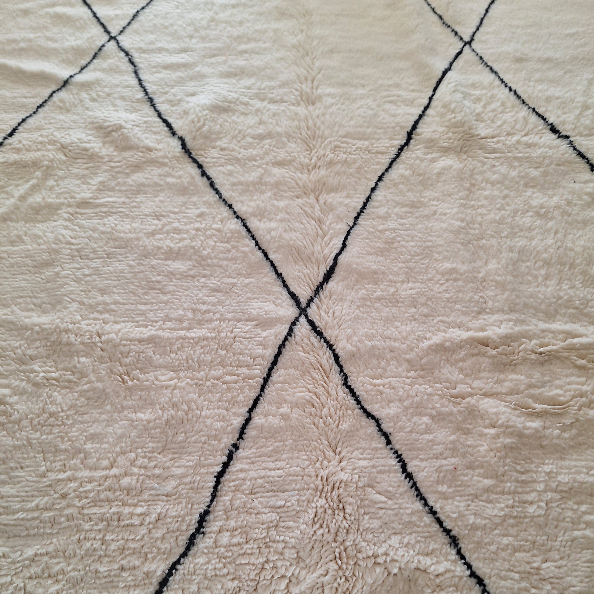 Tapis en laine écru et motifs noirs 